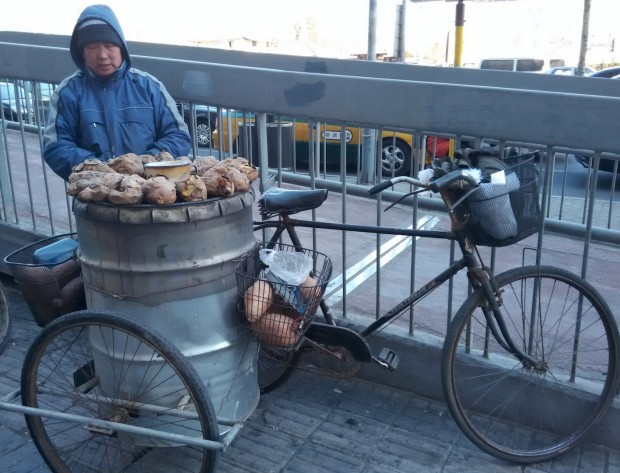 Chinês oferta batata doce assada a quem passa na rua